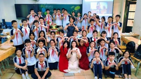 Cô gái trẻ xinh đẹp hạnh phúc thổi nến bánh sinh nhật trong không gian ấm cúng được trang trí đèn lung linh.