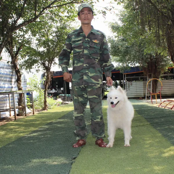 Một chú Doberman vui vẻ chơi đùa cùng gia đình trong sân vườn, thể hiện sự hòa nhập và tình cảm với trẻ nhỏ.