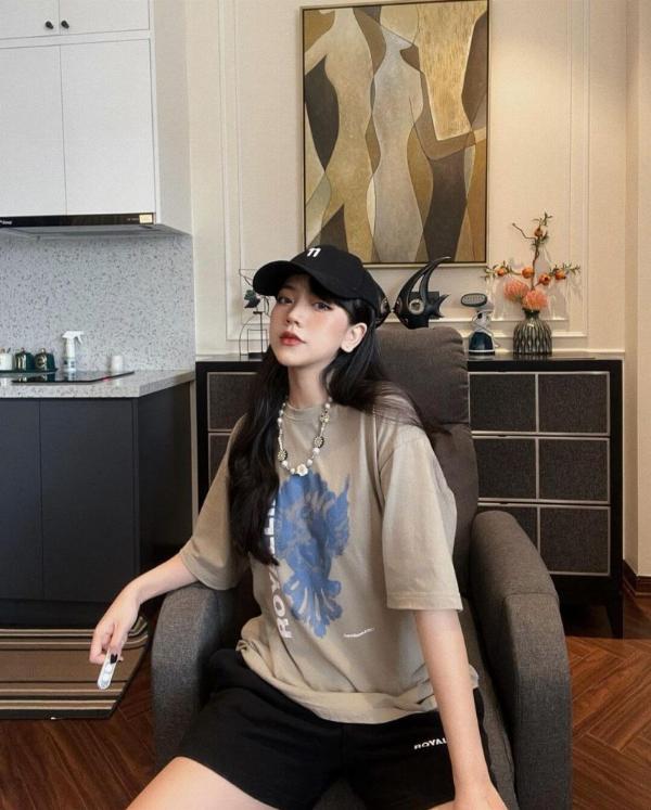 Một người phụ nữ tạo dáng chụp ảnh đứng với chân chữ A, tay chống hông để hack dáng thon gọn và cao ráo.